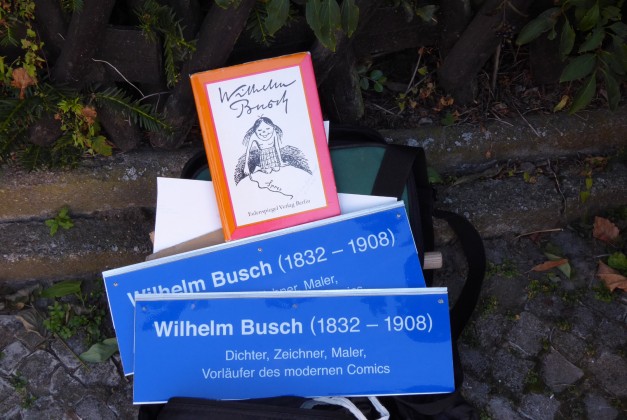 Ein Buch von Wilhelm Busch und zwei Zusatzstraßenschilder für Wilhelm Busch