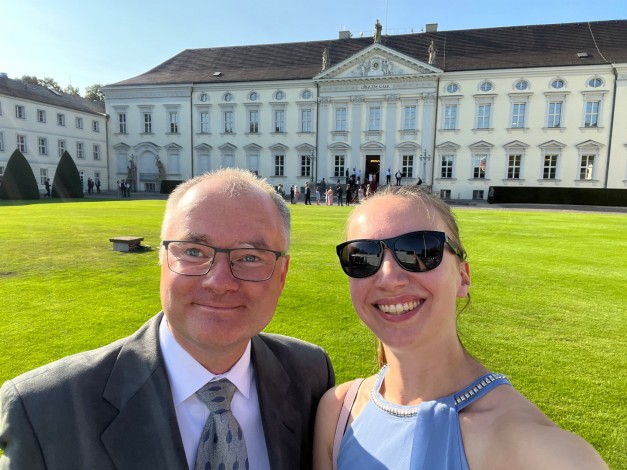 Zwei Personen stehen vor dem Schloss Bellevue und machen ein Selfie